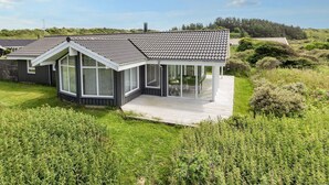 A modern house with a large deck, surrounded by lush greenery. - 4 Star Holiday Home in Hjorring (Hjørring)