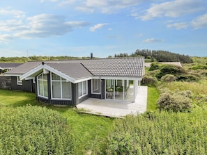 A modern house with a large deck, surrounded by lush greenery. - 4 Star Holiday Home in Hjorring (Hjørring)
