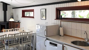 A compact kitchen with a dishwasher, a sink, and a dining area with chairs and a table. - 6 Person Holiday Home in Rodby-by Traum (Rodby)