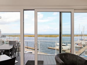 A deck with a view of a marina and open water. - Holiday Home in Wendtorf (Schönberg)