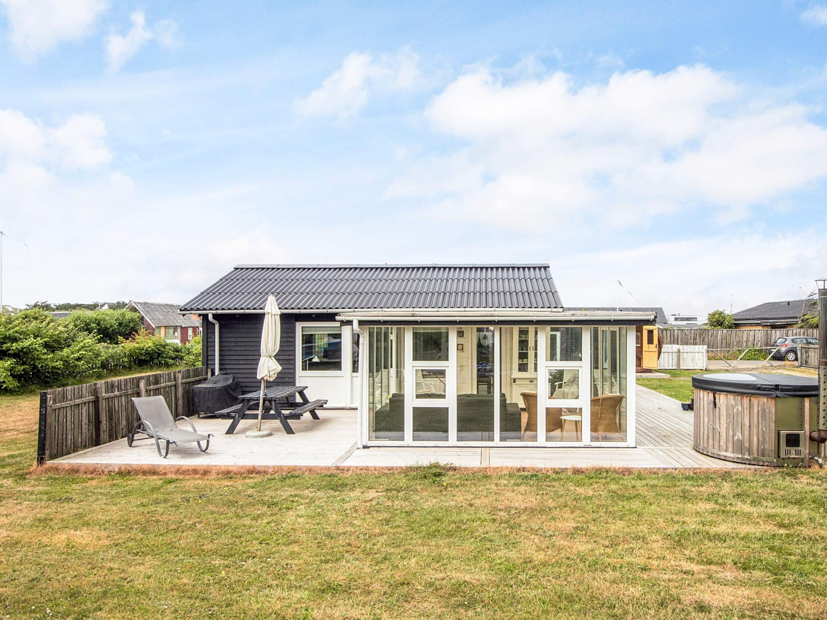 A house with a patio, a covered outdoor seating area, and a fenced backyard.