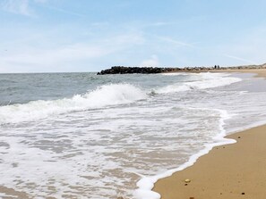 A beach with waves, a rocky outcrop, and a clear sky. - 4 Star Holiday Home in Ulfborg (Ulfborg)