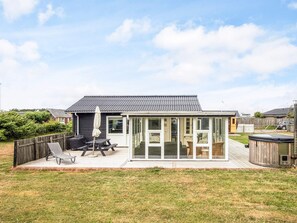 A house with a patio area, a sliding glass door, and a small deck. - 4 Star Holiday Home in Ulfborg (Ulfborg)