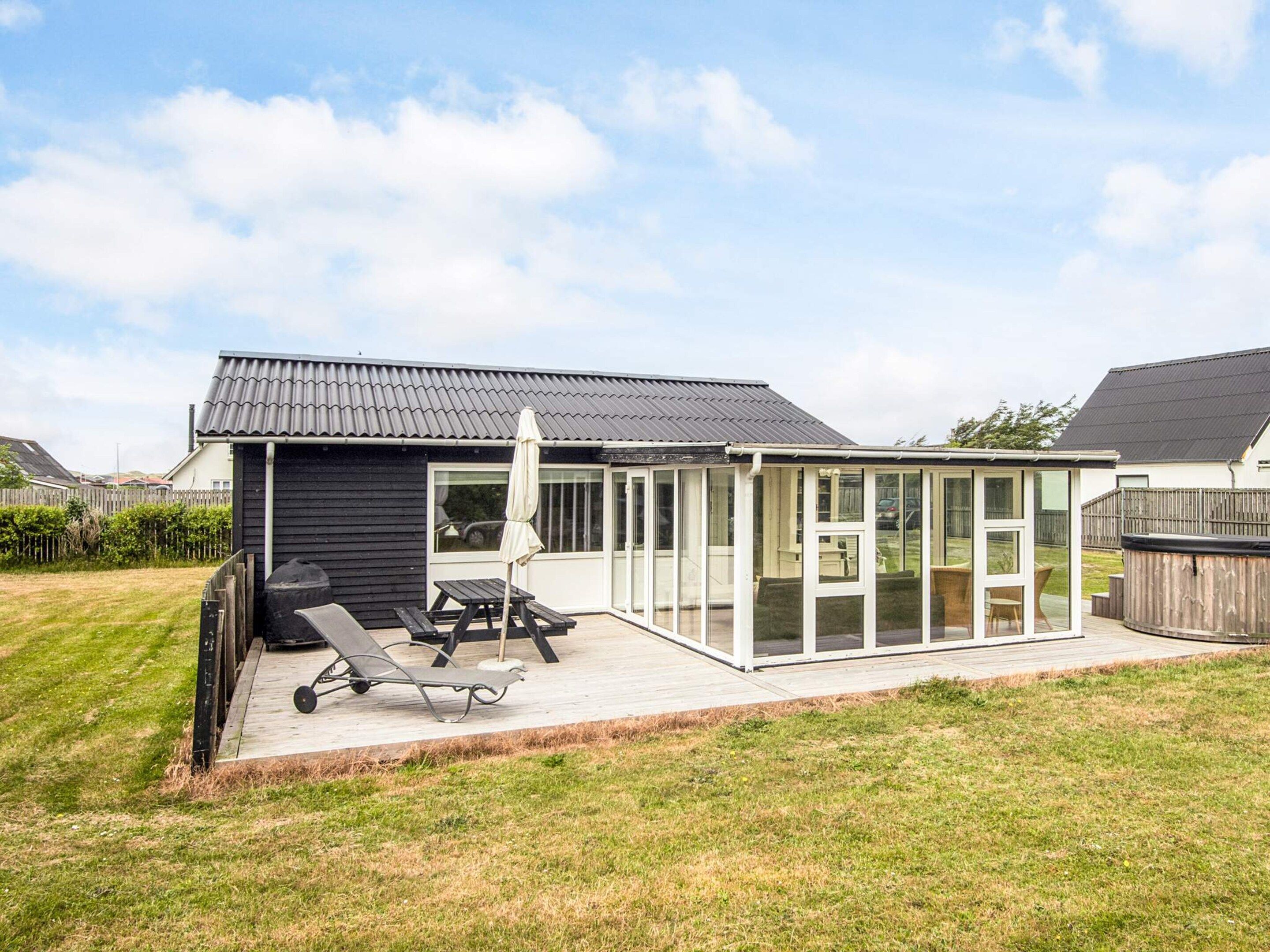 Une maison dotée d’un patio, d’un espace barbecue et d’un coin salon extérieur abrité.