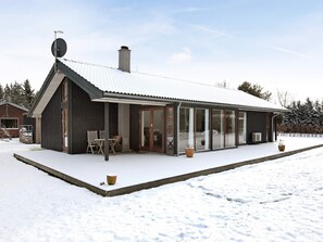 A modern house with a covered porch, large windows, and a snow-covered roof. - 4 Star Holiday Home in Dannemare (Dannemare)