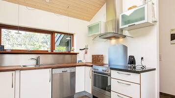 A modern kitchen with a dishwasher, oven, and a built-in microwave.