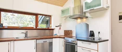 Una cocina moderna equipada con lavavajillas, horno y microondas integrados.
