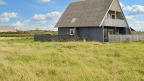 Einbungalow mit geneigtem Dach und umzäuntem Garten.