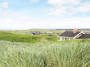 A coastal landscape with houses and grassy terrain. - 4 Star Holiday Home in Lokken (Lokken)