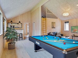 A pool table with balls, a sofa, a TV, and a staircase. - Holiday Home in Kappeln (Kappeln)