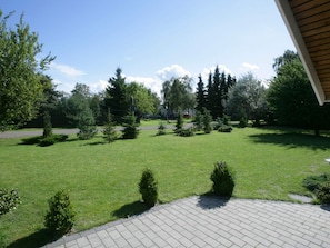 A well-maintained grassy area with a paved walkway, surrounded by trees and shrubs. - 5 Star Holiday Home in Vaeggerlose (Vaeggerlose)