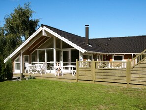 A house with a covered patio area, a chimney, and a fenced deck.