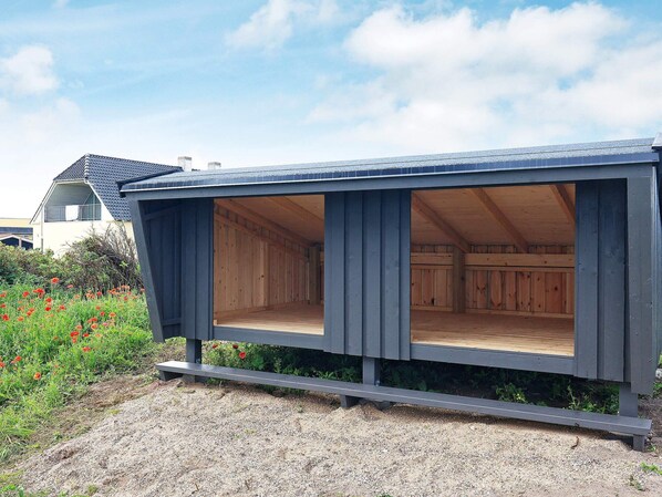 Una estructura moderna de madera con ventanas amplias y suelo de grava.