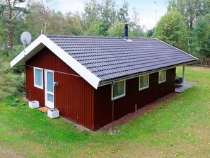 A small, single-story building with a dark red exterior, a sloped roof, and a small porch area. - Cozy Holiday Home in Læsø near Sea (Læsø)