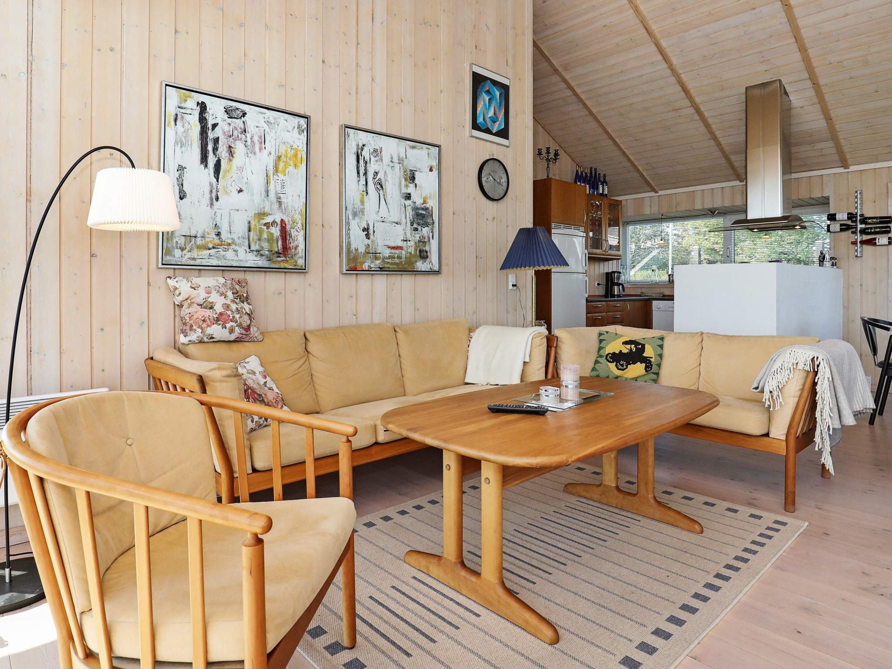 A cozy living room with a sofa, chairs, a coffee table, and artwork on the walls.