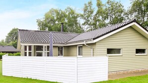 A single-story house with a sloped roof, a fenced yard, and a clear sky. - 6 Person Holiday Home in Ansager-by Traum (Ansager)