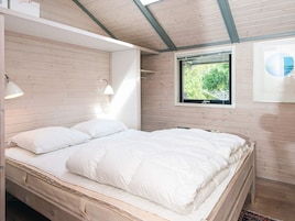 Un dormitorio con cama, ventana y lámpara.