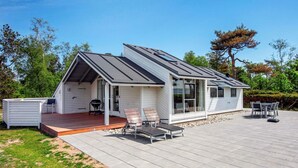 A modern house with a covered patio, a barbecue area, and a deck. - Exquisite Holiday Home in Knebel near Sea (Knebel)
