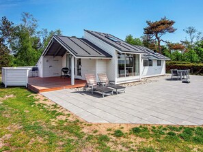 A modern house with a covered patio, a barbecue area, and a deck.