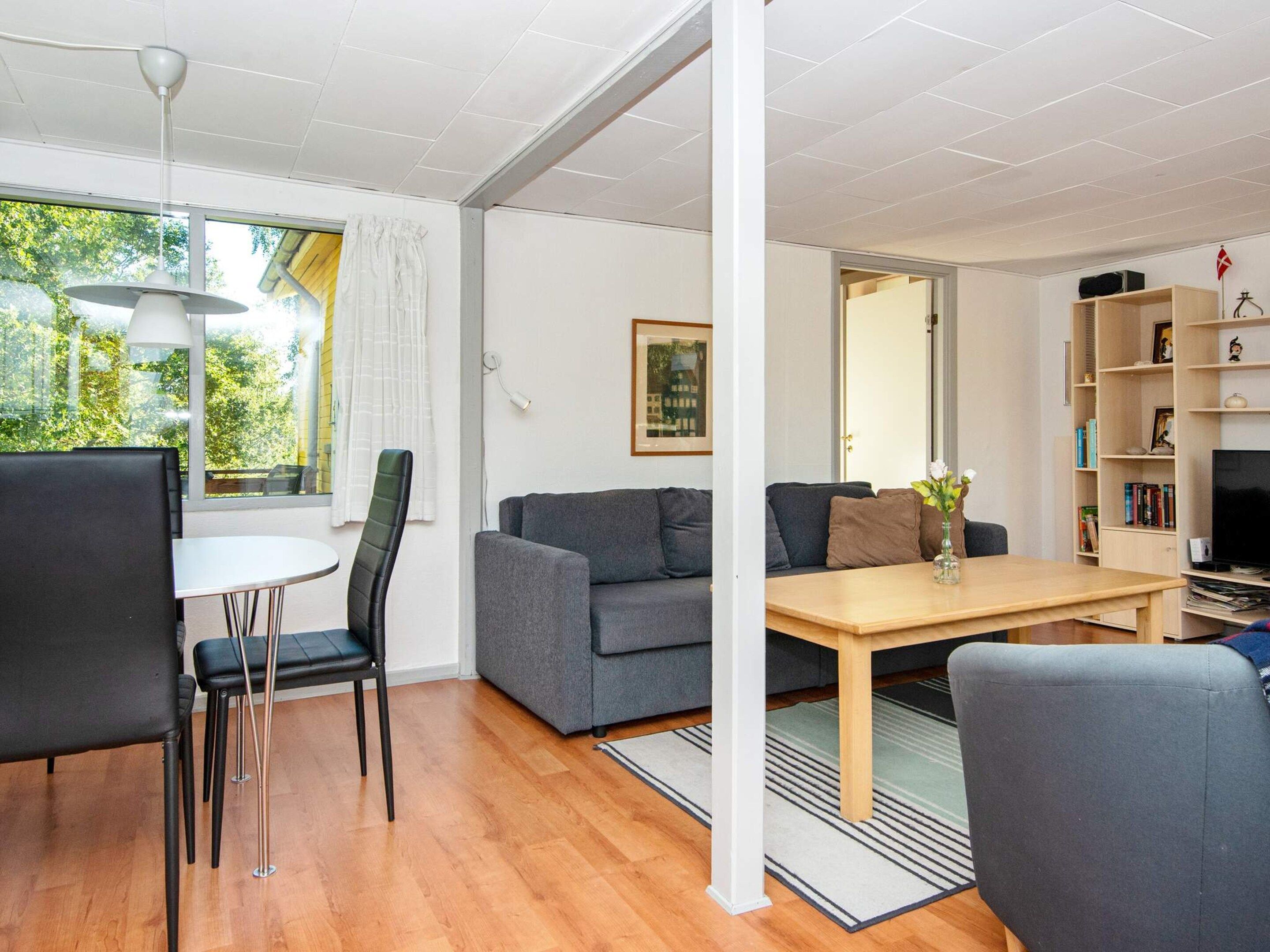 Una sala de estar moderna con sofá, mesa de comedor y televisor.
