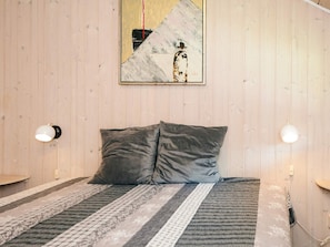 A bed with two pillows, a patterned bedspread, and a wall-mounted painting. - 5 Star Holiday Home in Tarm (Tarm)