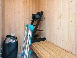 A sauna room with a wooden bench, a black shelf, and a trash bin. - 5 Star Holiday Home in Tarm (Tarm)