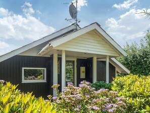 A house with a covered porch, a satellite dish, and a window.
