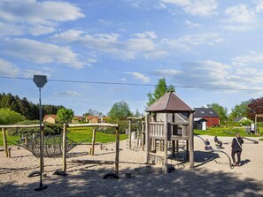 A playground with a wooden climbing structure and a small pavilion. - 6 Person Holiday Home in Glesborg (Glesborg)