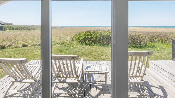 A wooden deck with a view of the beach and ocean. - 4 Star Holiday Home in Hjorring (Hjørring)