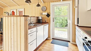 Eine Küche mit Holzausstattung, einer Kaffeemaschine und einem Spülbecken.