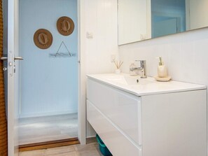 A bathroom with a white sink, a mirror, and a door with a light switch. - Peaceful Holiday Home in Fjerritslev near Beaches (Sjølund)