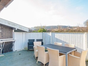A patio with a table and chairs, a wooden deck, and a white fence. - Peaceful Holiday Home in Fjerritslev near Beaches (Sjølund)