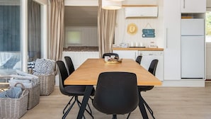 A modern kitchen with a wooden dining table, black chairs, and a hanging light fixture. - Peaceful Holiday Home in Fjerritslev near Beaches (Sjølund)