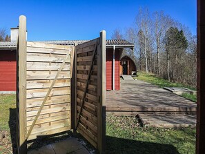A wooden gate leading to a building with a red exterior and a covered porch. - Pretty Holiday Home in Ålbæk near Sea (Aalbaek)