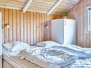 Cozy bedroom with a single bed, wall-mounted lamps, and a wardrobe for storage.