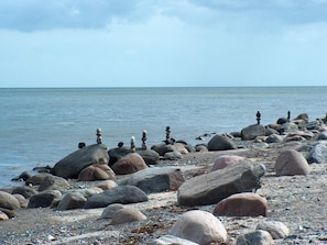 A rocky shoreline with large boulders and a calm sea.