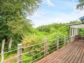 A wooden deck with a rope fence, overlooking a forested area. - Quaint Holiday Home near Glesborg with Roofed Terrace (Glesborg)