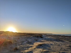 A beach with sand dunes and a clear sky.