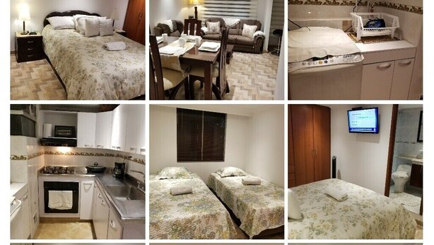 A hotel room with a bed, a desk with a computer, a TV, a dining area, and a bathroom. - Nice Apartment 5 Minutes Airport (Bogotá)