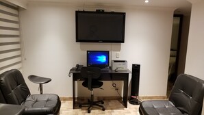 A modern office space with a desk, computer, and two leather chairs. - Nice Apartment 5 Minutes Airport (Bogotá)