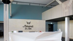 A reception desk with a wooden backdrop and the text "Mariandi am Meer". - Beautiful apartment for 2 people with WIFI, pool, TV, terrace and pets allowed (Sassnitz)