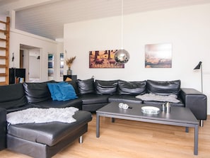 A modern living room with a sectional sofa, a coffee table, and artwork on the walls. - 4 Star Holiday Home in Vejers Strand (Vejers Strand)