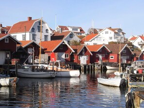 A harbor with boats docked and red-roofed buildings in the background. - 2 Person Holiday Home in Kungshamn (Kungshamn)