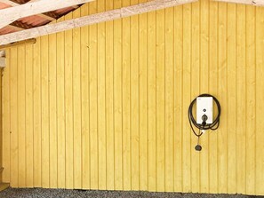 A room with a yellow wooden wall and a power outlet with a cable. - 4 Star Holiday Home in Vaeggerlose (Vaeggerlose)