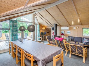 Un intérieur de chalet chaleureux avec un coin repas, des sièges et une cheminée.