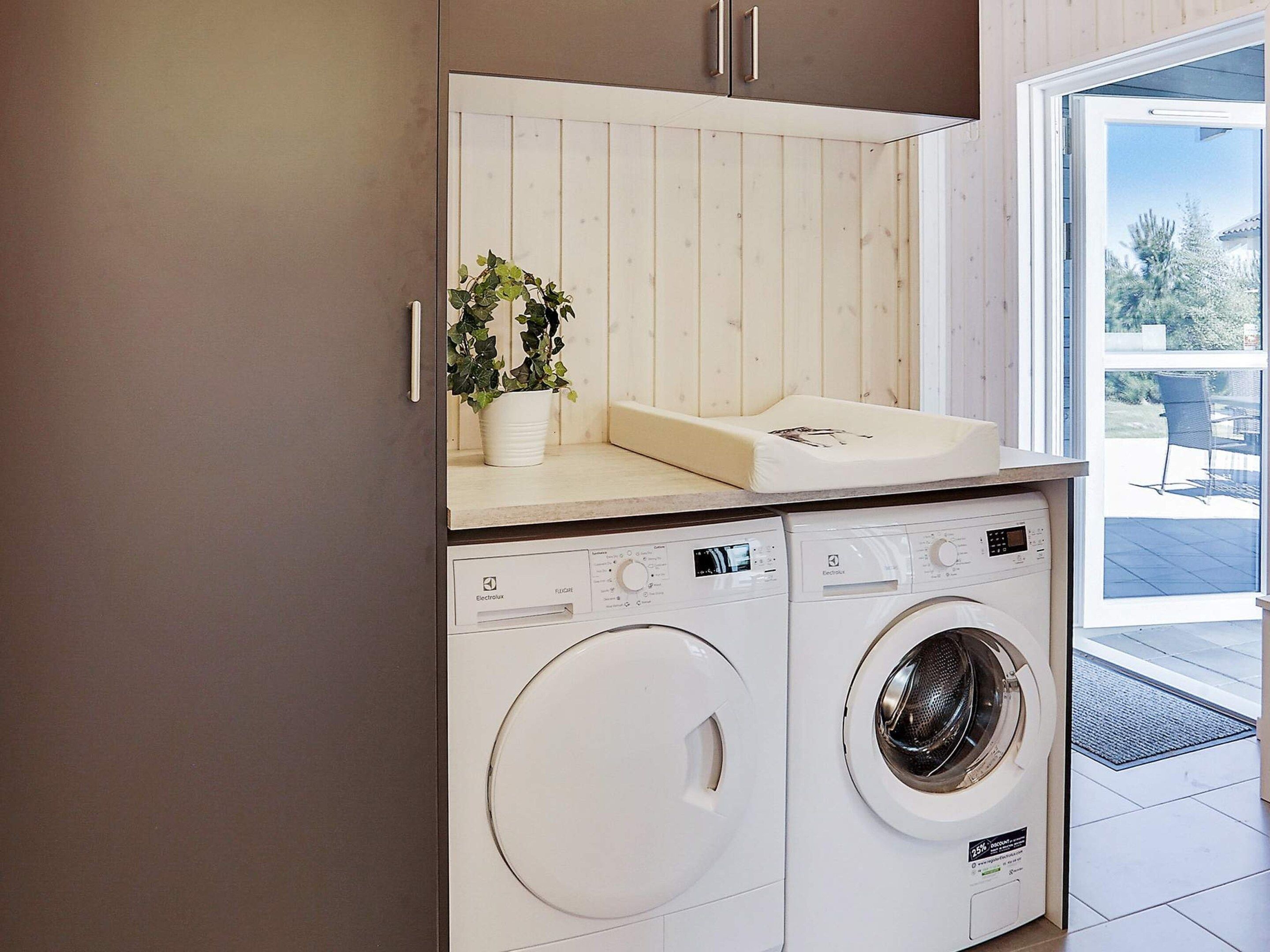 A compact laundry area with two washing machines and a sink.