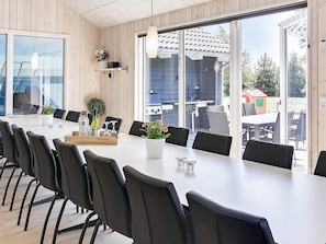 A conference room with a long table and chairs, large windows, and a view of the outdoors. - Luxury Holiday Home in Falster near Sea (Vaeggerlose)