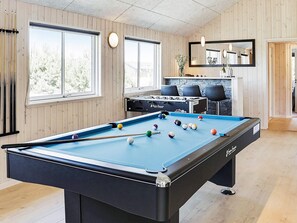 A pool table with balls, a foosball table, and a billiard cue rack. - Luxury Holiday Home in Falster near Sea (Vaeggerlose)