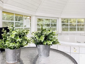 Two potted plants on a round table in a bright room with large windows. - 12 Person Holiday Home in Vaeggerlose (Vaeggerlose)