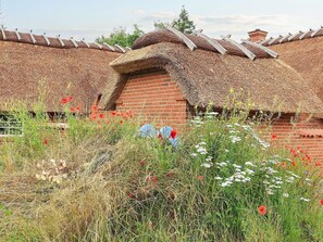 A traditional brick building with a thatched roof and a small brick extension. - 12 Person Holiday Home in Vaeggerlose (Vaeggerlose)